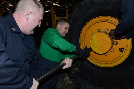 Aviation Support Equipment Technician 1st Class Richard Collier, a native of Denton, Texas and Aviation Support Equipment Technician 2nd Class Kris Nielsen from Snellville, Ga. change a 900-pound tire from a 10k forklift aboard the multipurpose amphibious assault ship USS Bataan (LHD 5) Feb. 10.  The Bataan Amphibious Readiness Group is deployed supporting maritime security operations, providing crisis response capability, increasing theater security cooperation and a forward naval presence in the U.S. Navy's 5th and 6th Fleet Area of Responsibility. (U.S. Navy Photo by Mass Communication Specialist 3rd Class Mark Hays/Released)