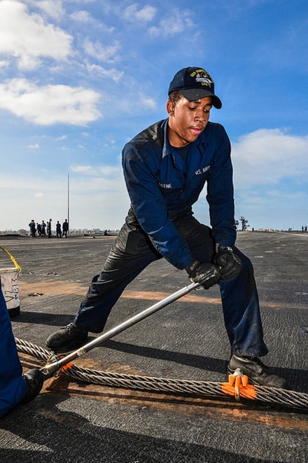 SAN DIEGO (April 23, 2014) Aviation Boatswain's Mate (Equipment) Airman Malikia Greene, from Dacula, Ga., tightens a clamp on an arresting gearwire aboard aircraft carrier USS Ronald Reagan (CVN 76). Ronald Reagan is currently moored and homeported at Naval Base Coronado.