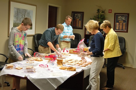 Community Foundation staff members and volunteers convert the board room into a sandwich assembly line to help feed hungry children. 