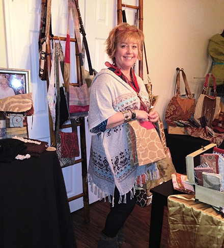 Denise Smith, founder of Peace of Thread is shown among the many bags available to help support women with a substantive job