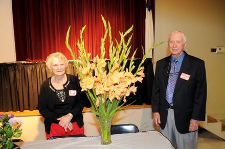 Ann Britt, class of 55 and Snell Buchanan, class of 56, besides the flowers from the memorial service for class members who have passed away in the last year.