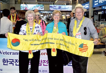 Jeannie Walters, Vada Timberlake and James Walters, holding banner upon their arrival at Inchon Airport.
