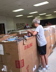 Lawrenceville’s Mayor Judy Johnson lends a helping hand to organize books to be distributed to students at Lawrenceville Elementary School.