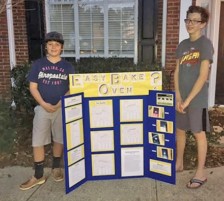 Hunter delValle and Austin Moore display their science fair project and results.