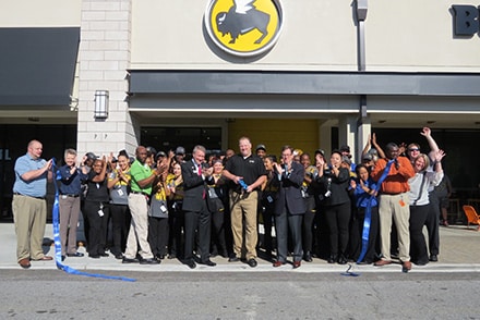 Steve Thomas, Buffalo Wild Wings general manager (center of photo wearing black shirt and khakis) along with Peachtree Corners councilmembers Weare Gratwick (wearing dark suite and red tie) and Eric Christ (wearing dark slacks, jacket and light blue shirt), along with employees join in the ribbon cutting celebration which took place at 9:15 a.m. Monday, May 15.