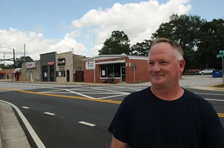 John Lange on Grayson Parkway with the buildings that will be renovated on the corner of Grayson Parkway and Grayson Hwy (Highway 20)