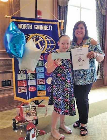 Lexi Flanders pictured with Barbara Bostwick, receives a $200 donation from the Kiwanis Club of North Georgia for Pedals of Courage.