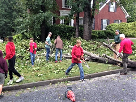 The troop spent the day removing fallen trees from lawns and driveways, cleared debris, and carried away tree limbs from those affected by the storm and high winds.