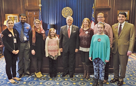 State Rep. Chuck Efstration, right, and Gov. Nathan Deal, center, pose for a photo with sepsis survivor Karen Thieken, center right, along with her family and colleagues at the state Capitol in March.