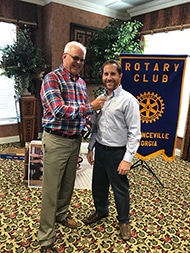 Craig Roberts is being awarded a gold star from the Assistant Governor of Rotary District 6910.