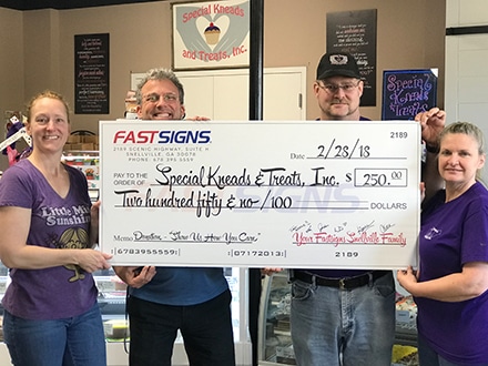 FASTSIGNS of Snellville presenting their $250 donation to Special Kneads & Treats Bakery