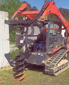 Jackson EMC employee helps out digging holes with auger
