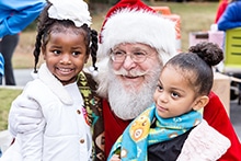 Santa with a Couple of Children from Rainbow Village Holidays 2017.