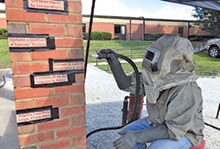 Chris Constant engraves bricks in preparation for ribbon cutting ceremony.