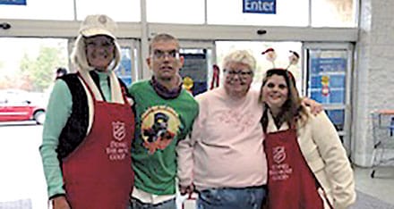Ringing the bell for the Salvation Army is Rotarian Nina Freeman and three of our Creative Enterprises clients.