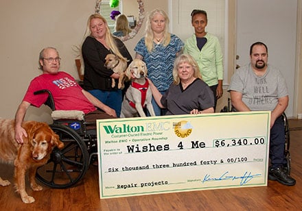 Lynn Robinette, front center, president of Wishes 4 Me Foundation, seeks to provide as normal a life as possible to those dealing with a disability. The residents and staff pictured with her will greatly benefit from a recent Walton EMC Operation Round Up grant.