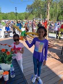 Sisters Elizabeth (age seven )and Tina Alfred (age ten) enjoy a day with their family at the new Town Green in Peachtree Corners. "I feel happy. We can bring [our dog] Zip here!" Elizabeth said.