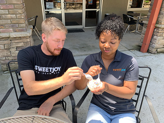 Co-owners Talia Holmes and her fiance Matt Mrorinzki enjoy a frozen treat at Sweet Joy Ice Cream Bar on Honest Alley in Downtown Lawrenceville.