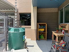 Master Gardeners with UGA Extension Gwinnett aided Ofice in installing raised garden beds in the Norcross Senior Center’s outdoor patio where they utilize a rain catcher and a compost heap.