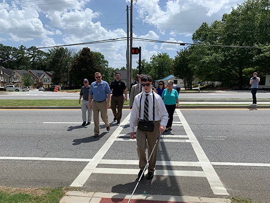 Timothy Jones, crossing Beaver Ruin Rd. independently at the new crosswalk with Hawk Signal created by Gateway85 and funded by the Georgia DOT and the Gwinnett DOT, among others.