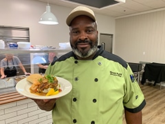 Chef Hank Reid serves dinner at First Baptist Church Snellville. His personal mantra is “LETTUM EAT!” which simply means “Serve Them”, overcome any obstacles and make it happen . . . whatever “it” may happen to be.  