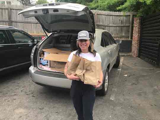 Universal Joint manager Rebecca Williams loads individually-packaged meals, headed to healthcare workers at Northside Gwinnett