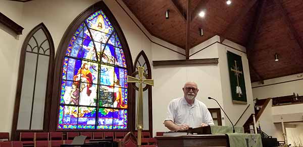 Dr. Jim Cantrell in front of the stain glass and altar at Snellville United Methodist Church