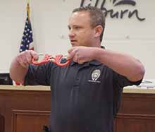 Sgt. Rob Kirschner of the Lilburn Police Department demonstrates how handcuffs (used by police officers) lock into place.