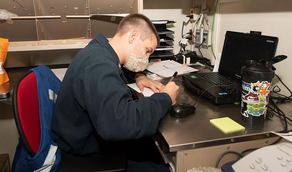 Lilburn native fills out a postal directory form in the post office aboard USS Ralph Johnson. (U.S. Navy Photo by Mass Communication Specialist 3rd Class Anthony Collier)