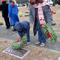 Philadelphia Winn DAR member Anne Lockhart instructs her grandson, Nick H. how to honor and remember a veteran by laying a wreath on his grave during the 2020 Wreaths Across America Ceremony.