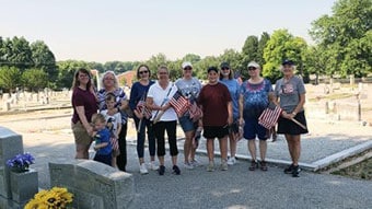 Philadelphia Winn NSDAR and Elisha Winn Society C.A.R. (Children of the American Revolution) members prepare to place American flags on veterans’ graves at the Snellville Historical Cemetery for Memorial Day.