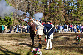 The Georgia Society Sons of the American Revolution SAR color guard and militia fire a three musket volley during the Wreaths Across America ceremony to honor fallen veterans