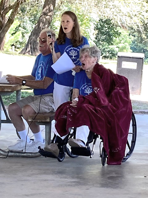 Bill, Lois, and Mrs. Pentecost lifting their voices in song during festivities. 