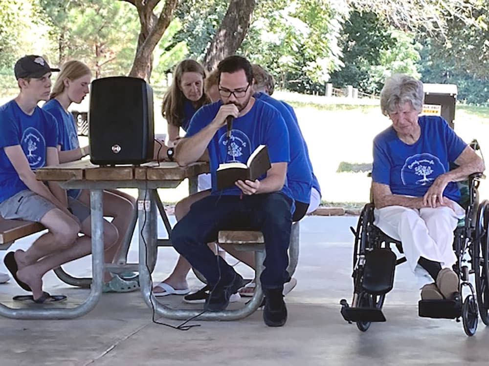 Grandchild Arthur Anderson reads Bible scripture to the group.